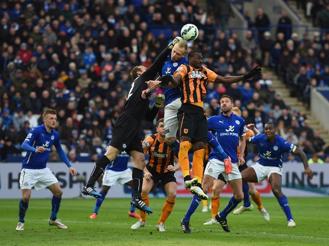 Mark Schwarzer of Leicester City punches the ball clear of Dame N'Doye of Hull and Ritchie De Laet of Leicester City during the Barclays Premier League match between Leicester City and Hull City at The King Power Stadium on March 14, 2015