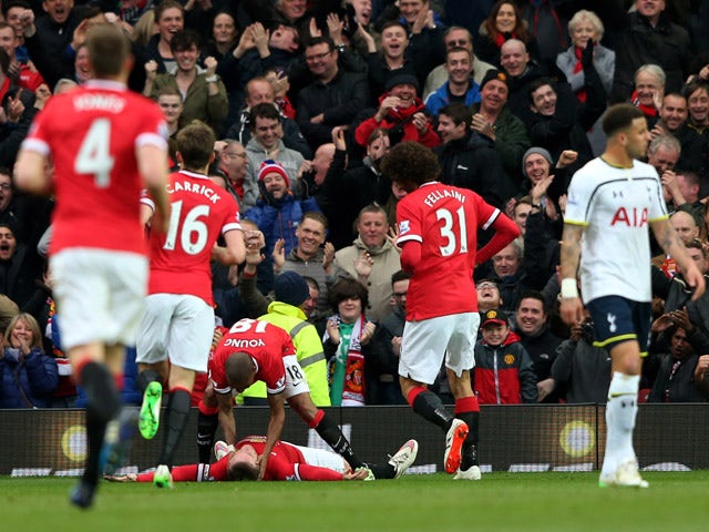 Wayne Rooney of Manchester United is congratulated by teammates after scoring his team's third goal during the Barclays Premier League match between Manchester United and Tottenham Hotspur at Old Trafford on March 15, 2015
