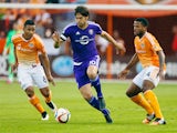 Kaka #10 of the Orlando City SC moves with the ball between Luis Garrido #8 and Jermaine Taylor #4 of the Houston Dynamo during their game at BBVA Compass Stadium on March 13, 2015