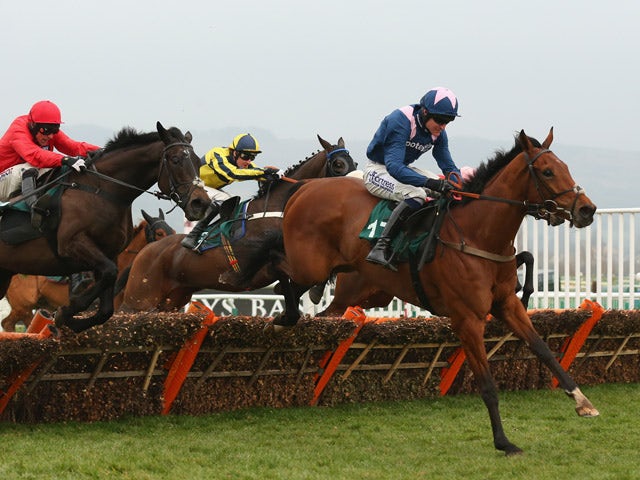 Qualando ridden by Nick Scholfield clears the last fence on their way to victory in the Fred Winter Juvenile Handicap Hurdle during Ladies Day at the Cheltenham Festival at Cheltenham Racecourse on March 11, 2015