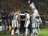 Juventus' Argentinian forward Carlos Tevez (hidden) celebrates scoring with his team-mates scores the 0-1 goal during the Round of 16 second-leg UEFA Champions League football match  against Dortmund on March 18, 2015