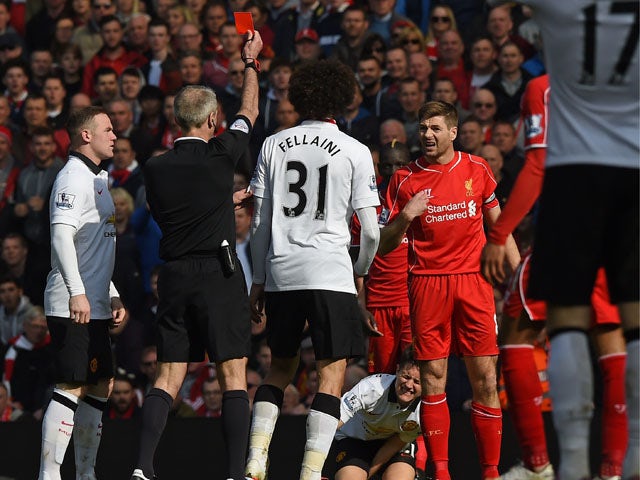 Liverpool's English midfielder Steven Gerrard is shown a red card by referee Martin Atkinson (2nd L) in the first minute of the second half, after coming on as substitute at half time in the English Premier League football match between Liverpool and Manc