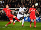 Bafetimbi Gomis of Swansea City is closed down by Martin Skrtel and Emre Can of Liverpool during the Barclays Premier League match between Swansea City and Liverpool at Liberty Stadium on March 16, 2015