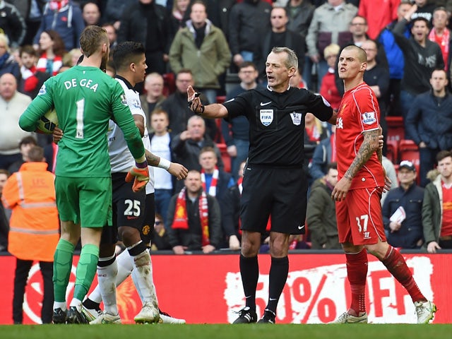 Referee Martin Atkinson separates Manchester United's Spanish goalkeeper David de Gea and Liverpool's Slovakian defender Martin Skrtel during the English Premier League football match between Liverpool and Manchester United at Anfield in Liverpool, north 