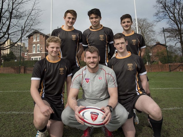 Mark Cueto poses with a group of boys and a rugby ball