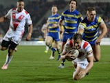 Jon Wilkin of St Helens scores a first half try past Matty Russell of Warrington Wolves during the First Utility Super League match between St Helens and Warrington Wolves at Langtree Park on March 19, 2015