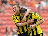 Nathan Burns of Wellington Phoenix is congratulated by team mate Michael McGlinchey after scoring a goal during the round 22 A-League match between the Brisbane Roar and the Wellington Phoenix at Suncorp Stadium on March 22, 2015