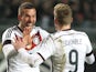 Germany's midfielder Lukas Podolski (L) celebrates scoring the 2-2 goal with midfielder Andre Schuerrle during the friendly football match Germany vs Australia in Kaiserslautern, southern Germany on March 25, 2015