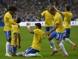 Brazil's midfielder Luiz Gustavo is congratulated by teammates after scoring a goal during the friendly football match France vs Brazil, on March 26, 2015