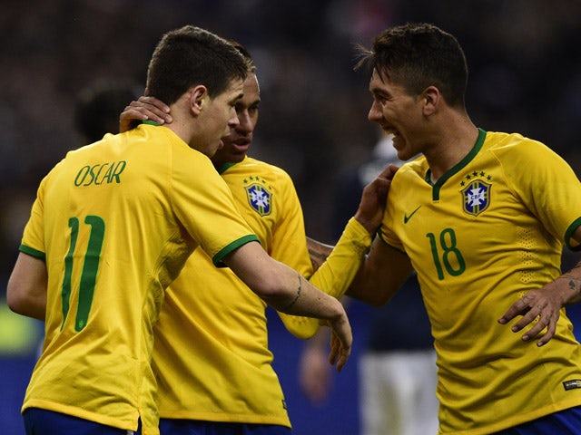 Brazil's forward Oscar is congratulated by teammates after scoring a goal during the friendly football match France vs Brazil, on March 26, 2015