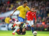 Firmino of Brazil rounds goalkeeper Claudio Bravo of Chile to score the opening goal during the international friendly match between Brazil and Chile at the Emirates Stadium on March 29, 2015