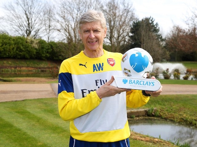 Arsene Wenger poses proudly with his Manager of the Month award for March 2015