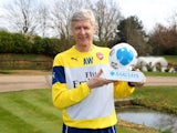 Arsene Wenger poses proudly with his Manager of the Month award for March 2015