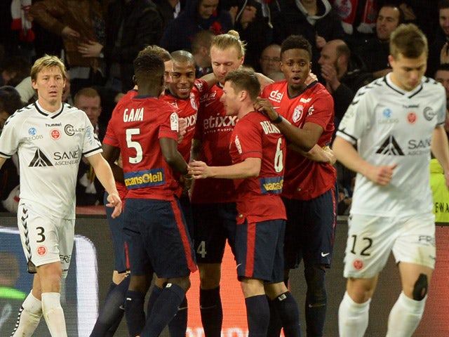 Lille's belgian forward Divock Origi is congratulated by teammates after scoring a goal during the French Ligue football match Lille vs Reims on April 4, 2015 