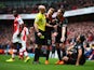 Jordan Henderson of Liverpool and Lucas Leiva of Liverpool argue with referee Anthony Taylor as Emre Can of Liverpool sits on the turf during the Barclays Premier League match between Arsenal and Liverpool at Emirates Stadium on April 4, 2015