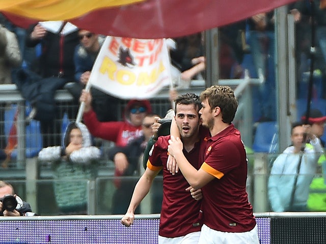 Roma's midfielder from Bosnia-Herzegovina Miralem Pjanic is congratulated by teammate Roma's forward from Serbia Adem Ljajic after scoring during the Italian Serie A football match between AS Roma and Napoli on April 04, 2015
