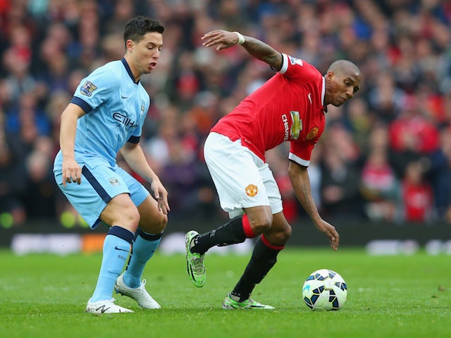 Ashley Young of Manchester United evades Samir Nasri of Manchester City during the Barclays Premier League match between Manchester United and Manchester City at Old Trafford on April 12, 2015