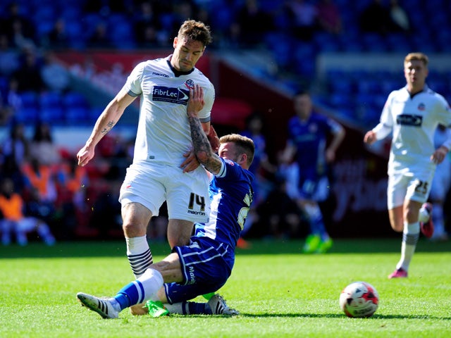 Bolton player Dorian Dervitte is challenged by Joe Ralls of Cardiff during the Sky Bet Championship match between Cardiff City and Bolton Wanderers at Cardiff City Stadium on April 6, 2015