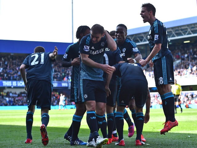 Chelsea's Serbian defender Branislav Ivanovic reacts to being hit by a coin as Chelsea players celebrate their goal during the English Premier League football match between Queens Park Rangers and Chelsea at Loftus Road Stadium in London on April 12, 2015