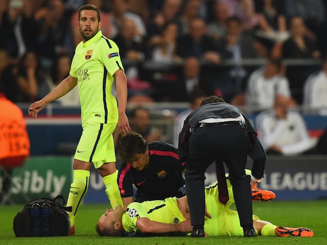 Andres Iniesta of Barcelona lies injured on the pitch during the UEFA Champions League Quarter Final First Leg match between Paris Saint-Germain and FC Barcelona at Parc des Princes on April 15, 2015