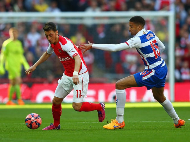 Mesut Ozil of Arsenal is marshalled by Michael Hector of Reading during the FA Cup Semi Final between Arsenal and Reading at Wembley Stadium on April 18, 2015 