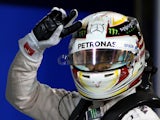 Mercedes AMG Petronas British driver Lewis Hamilton flashes the sign for victory after winning the pole position for the Formula One Bahrain Grand Prix following the qualification session at the Sakhir circuit in the desert south of the Bahraini capital, 