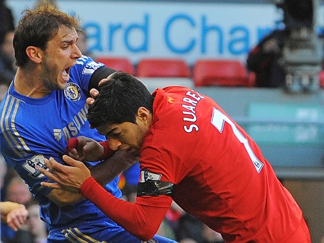 Liverpool's Uruguayan striker Luis Suarez clashes with Chelsea's Serbian defender Branislav Ivanovic after appearing to bite the Chelsea player during the English Premier League football match between Liverpool and Chelsea at the Anfield stadium in Liverp