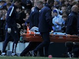 Manchester City's Spanish midfielder David Silva is carried off the field on a stretcher injured after taking a knock in the face in a challenge with West Ham United's Senegalese midfielder Cheikhou Kouyate during the English Premier League football match