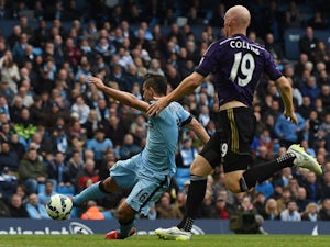 Manchester City's Argentinian striker Sergio Aguero (L) scores their second goal during the English Premier League football match between Manchester City and West Ham United at the Etihad Stadium in Manchester, north west England on April 19, 2015