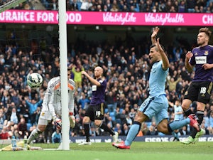 Manchester City's Argentinian striker Sergio Aguero follows up as the ball bounces into the goal after a big deflection off West Ham United's Welsh defender James Collins for a West Ham own goal to open the scoring during the English Premier League footba