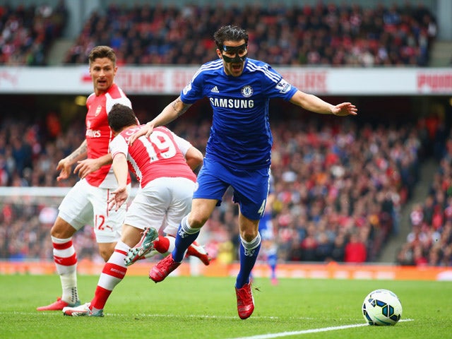 Cesc Fabregas of Chelsea is challenged by Santi Cazorla of Arsenal during the Barclays Premier League match between Arsenal and Chelsea at Emirates Stadium on April 26, 2015 