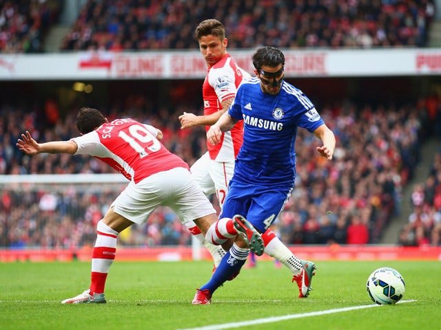Cesc Fabregas of Chelsea is challenged by Santi Cazorla of Arsenal during the Barclays Premier League match between Arsenal and Chelsea at Emirates Stadium on April 26, 2015