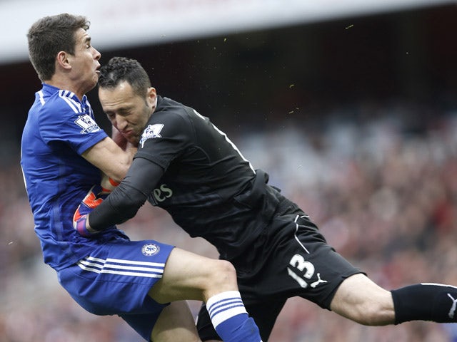 Arsenal's Colombian goalkeeper David Ospina collides with Chelsea's Brazilian midfielder Oscar during the English Premier League football match between Arsenal and Chelsea at the Emirates Stadium in London on April 26, 2015