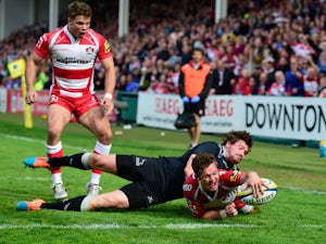 Gloucester player Billy Burns scores the winning try despite the attentions of Adam Powell during the Aviva Premiership match between Gloucester Rugby and Newcastle Falcons at Kingsholm Stadium on April 25, 2015