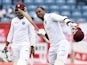 West Indies batsman Marlon Samuels celebrates after scoring his century as team captain/wicketkeeper Denesh Ramdin looks on during day two of the second Test match between West Indies and England at the Grenada National Stadium in Saint George's on April 