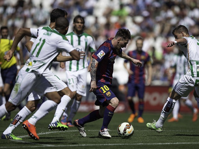 Lionel Messi of FC Barcelona competes for the ball with Aleksandar Pantic of Cordoba CF during the La Liga match between Cordoba CF and Barcelona FC at El Arcangel stadium on May 2, 2015