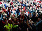 Captain Tommy Elphick of Bournemouth celebrates victory as fans invade the pitch after the Sky Bet Championship match between AFC Bournemouth and Bolton Wanderers at Goldsands Stadium on April 27, 2015