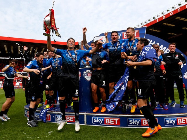 Tommy Elphick of Bournemouth lifts the trophy while Bournemouth players celebrate winning the Championship after the Sky Bet Championship match between Charlton Athletic and AFC Bournemouth at The Valley on May 2, 2015