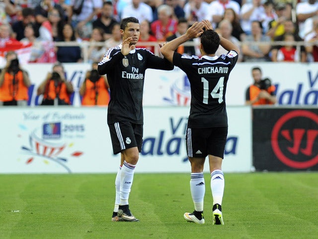 Real Madrid's Portuguese forward Cristiano Ronaldo celebrates with Real Madrid's Mexican forward Chicharito after scoring during the Spanish league football match Sevilla FC vs Real Madrid CF at the Ramon Sanchez Pizjuan stadium in Sevilla on May 2, 2015