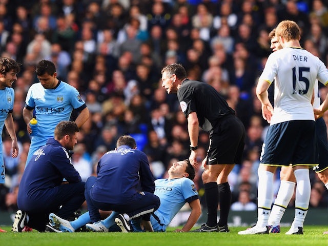 An injured Samir Nasri of Manchester City is given assistance as referee Andre Marriner looks on during the Barclays Premier League match between Tottenham Hotspur and Manchester City at White Hart Lane on May 3, 2015