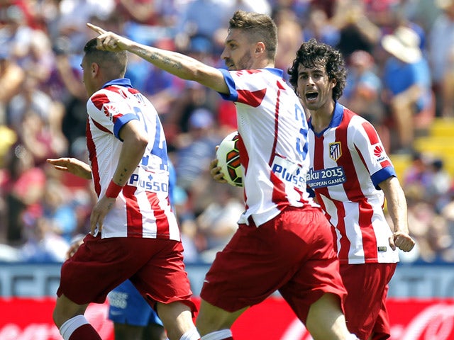 Atletico Madrid's Brazilian defender Guilherme Siqueira celebrates with teammates after scoring a goal during the Spanish league football match Levante UD vs Club Atletico de Madrid at the Ciutat de Valencia stadium in Valencia on May 10, 2015