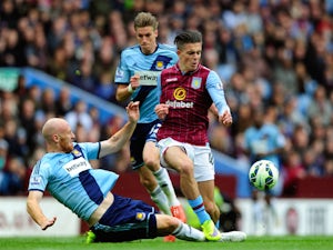 Jack Grealish of Aston Villa is tackled by James Collins of West Ham United during the Barclays Premier League match between Aston Villa and West Ham United at Villa Park on May 9, 2015