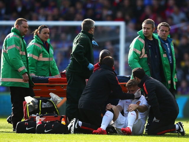 Luke Shaw of Manchester United receives treatment before leaving the field on a stretcher during the Barclays Premier League match between Crystal Palace and Manchester United at Selhurst Park on May 9, 2015