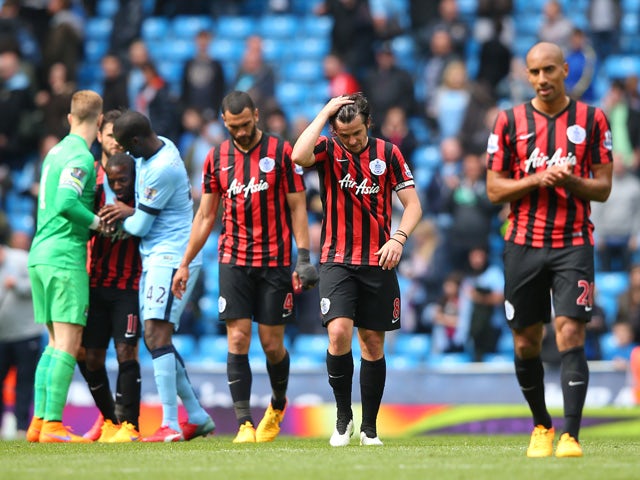 A dejected Joey Barton of QPR and teammates react following their team's relegation during the Barclays Premier League match between Manchester City and Queens Park Rangers at the Etihad Stadium on May 10, 2015