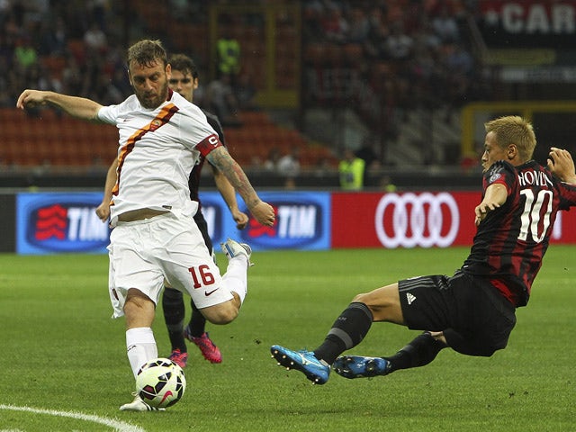 Daniele De Rossi of AS Roma is challenged by Keisuke Honda of AC Milan during the Serie A match between AC Milan and AS Roma at Stadio Giuseppe Meazza on May 9, 2015
