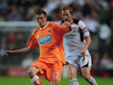 Tom Barkhuizen of Blackpool shields the ball from Dean Lewington of MK Dons during the Carling Cup 2nd Round match between MK Dons and Blackpool at Stadium MK on August 24, 2010