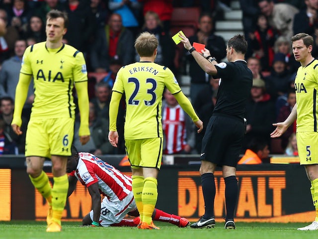 Vlad Chiriches (L) of Tottenham Hotspur leaves the field after being shown the red card by referee Mark Clattenburg during the Barclays Premier League match between Stoke City and Tottenham Hotspur at Britannia Stadium on May 9, 2015