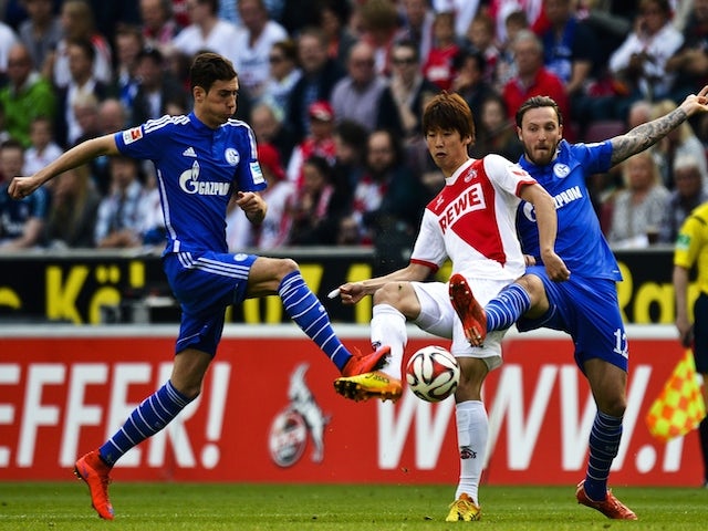 Cologne's Japanese striker Yuya Osako (C) vies for the ball with Schalke's midfielder Marco Hoeger (R) during the German first division Bundesliga football match of FC Cologne vs FC Schalke 04 in Cologne, western Germany on May 10, 2015