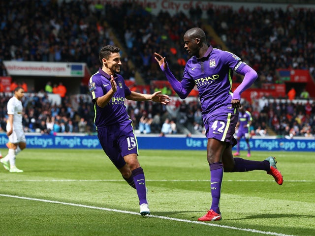 Yaya Toure of Manchester City is congratulated by teammate Jesus Navas of Manchester City after scoring his team's third goal during the Barclays Premier League match between Swansea and Manchester City at the Liberty Stadium on May 17, 2015