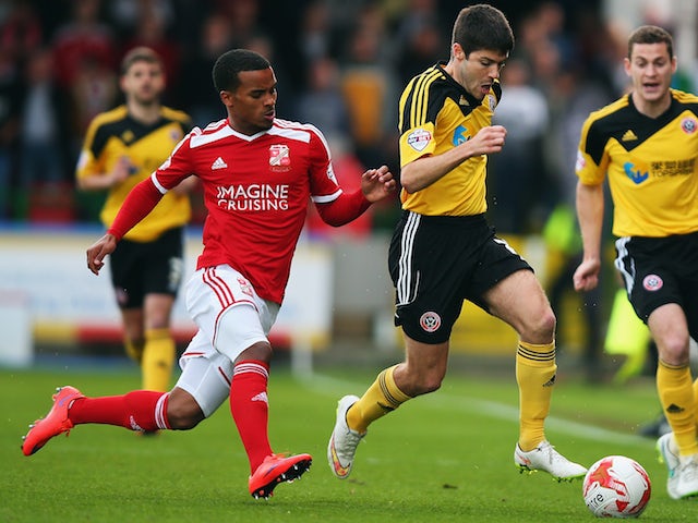 Nathan Byrne of Swindon Town tackles Ryan Flynn of Sheffield United during the Sky Bet League 1 Playoff Semi-Final between Swindon Town and Sheffiled United at County Ground on May 11, 2015